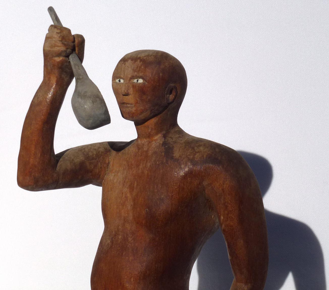 Carving of man drinking from ladle