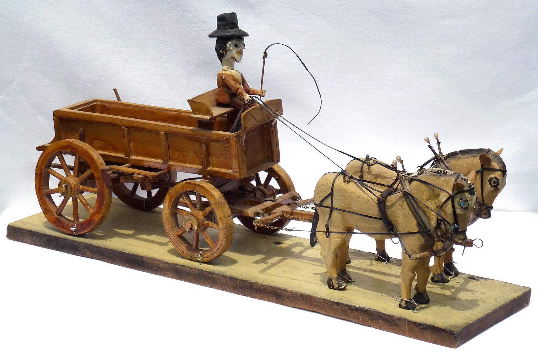 Carved man, horses, and wagon