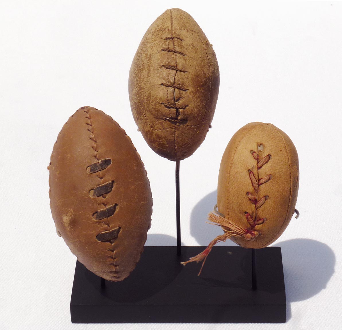 Three hand made miniature footballs